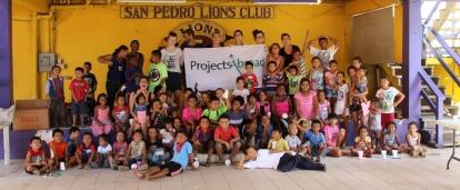 A group of Projects Abroad Childcare volunteers with a group of local children in Belize after their summer camp classes. Projects Abroad volunteers working with children in Belize celebrate the end of a successful summer camp with local children.